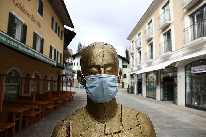 A art sculpture wearing a face mask in the deserted city of Berchtesgaden, Germany, Monday, Oct. 26, 2020. Authorities have posed the Berchtesgaden region under a lockdown since Oct. 20, 2020 due to a rising number of cases of the pandemic COVID-19 disease caused by the SARS-CoV-2 coronavirus in the district of Berchtesgadener Land. Local authorities in Bavaria's Rottal-Inn county, on the border with Austria, said Monday that the restrictions will begin at midnight. (AP Photo/Matthias Schrader)