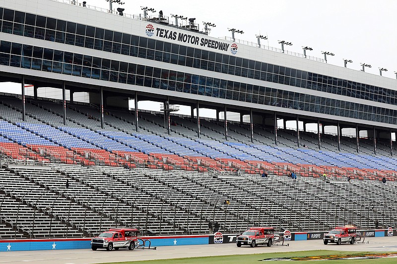 Drying trucks continue to prepare the track for a possible NASCAR Cup Series auto race at Texas Motor Speedway in Fort Worth, Texas, Tuesday, Oct. 27, 2020. The race was stopped on Sunday because of drizzle and misty conditions that allowed drivers to complete just 52 of 334 laps. Another 115 laps have to be completed to get to the halfway mark of 167 laps that would make Texas an official race. (AP Photo/Richard W. Rodriguez)