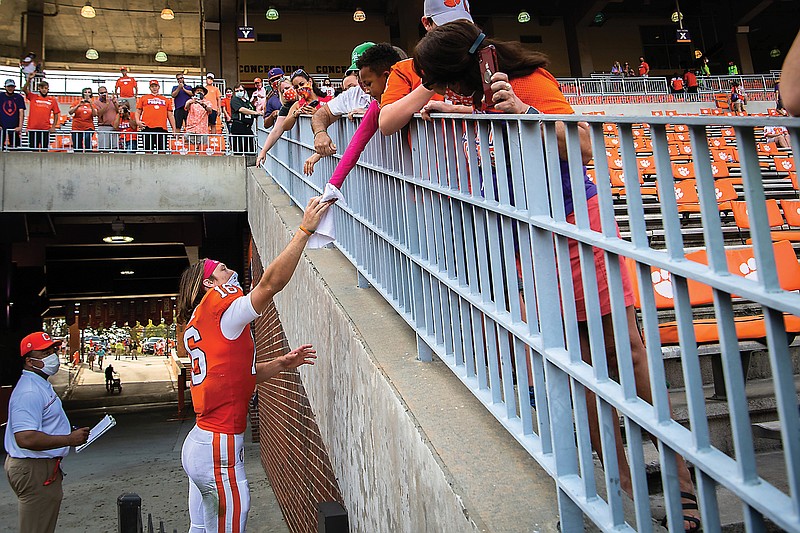 Clemson quarterback Trevor Lawrence hands a towel to Micah Chapman, 6, of Anderson, S.C., after Saturday's game against Syracuse in Clemson, S.C.