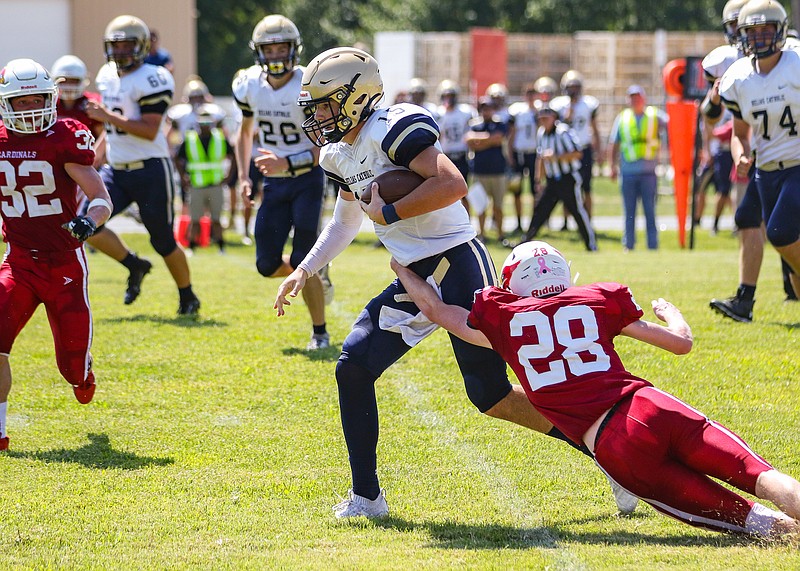 Tipton's Mikey Buckner goes for a tackle against Helias JV quarterback Drew Miller during a game earlier this season at Tipton.