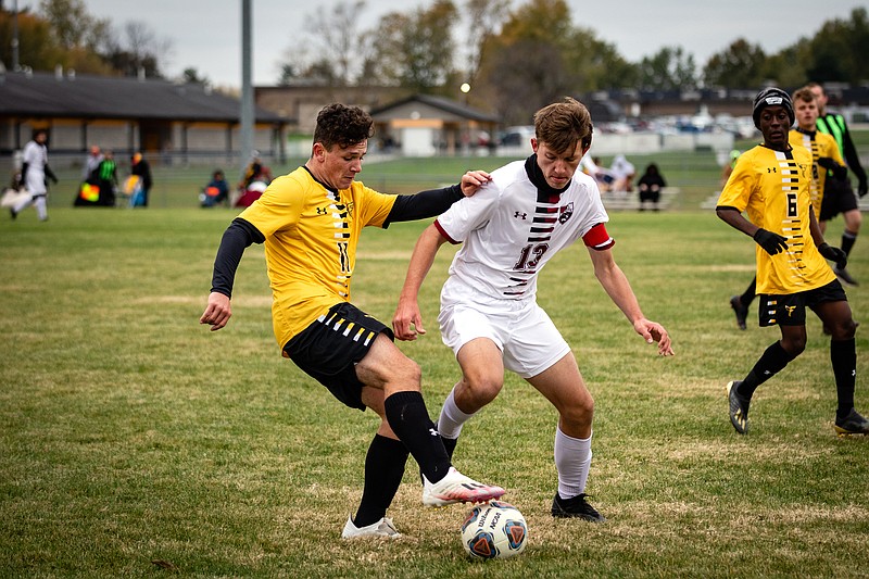 Fulton freshman midfielder Jayden Ayers possesses the ball against Canton junior Robert Sutton in the Hornets' 9-1 romp over the Tigers in Thursday night's regular-season finale at the high school athletic complex.