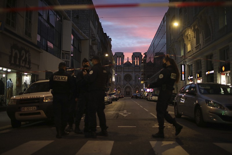 Police work behind a restricted zone near the Notre Dame church in Nice, southern France, after a knife attack took place on Thursday, Oct. 29, 2020. An attacker armed with a knife killed at least three people at a church in the Mediterranean city of Nice, prompting the prime minister to announce that France was raising its security alert status to the highest level. (AP Photo/Daniel Cole)