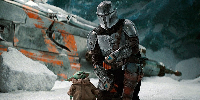 This image released by Disney Plus shows Pedro Pascal, as Din Djarin, right, with The Child, in a scene from "The Mandalorian," premiering its second season on Friday. (Disney Plus via AP)