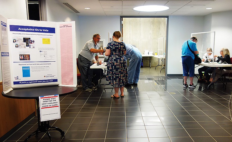 Voters sign in at the Fulton City Hall polling place during the August election. Similar safety measures will be in place during the general election Tuesday.
