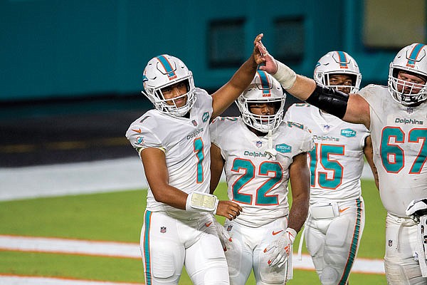 Dolphins quarterback Tua Tagovailoa celebrates his first NFL play with running back Matt Breida (22), guard Ted Karras (67) and running back Lynn Bowden (15) during a game Oct. 18 against the Jets in Miami Gardens, Fla. Tagovailoa will get his first NFL start today.