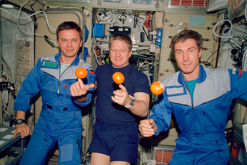 In this photo provided by NASA, the Expedition 1 crew members pose with fresh oranges onboard the Zvezda Service Module of the Earth-orbiting International Space Station on Dec. 4, 2000. Pictured, from left, are cosmonaut Yuri P. Gidzenko, Soyuz commander; astronaut Bill Shepherd, mission commander; and cosmonaut Sergei K. Krikalev, flight engineer. (NASA via AP)