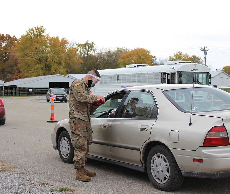 A member of the Missouri National Guard speaks with a community member at the Department of Health and Senior Services' community coronavirus testing event Wednesday, Nov. 4, 2020.