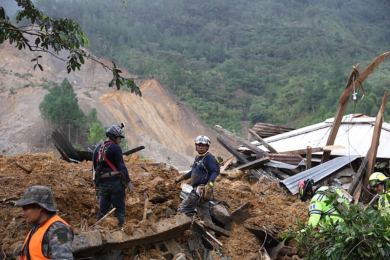 Members of search and recovery teams search for survivors in the debris of a massive, rain-fueled landslide in the village of Queja, in Guatemala, Saturday, Nov. 7, 2020, in the aftermath of Tropical Storm Eta. (Esteban Biba/Pool Photo via AP)