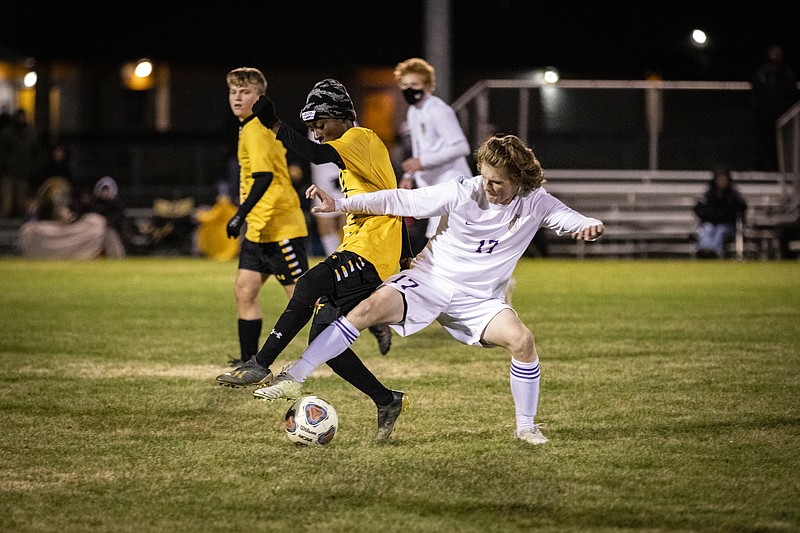 Fulton freshman midfielder Christian Mahoro (left) tries to gain possession of the ball against Pleasant Hill sophomore Ayden Jackson during Tuesday night's Class 2 state quarterfinal matchup at the high school athletic complex. The Hornets' season ended in a 2-1 loss to the Roosters in overtime.