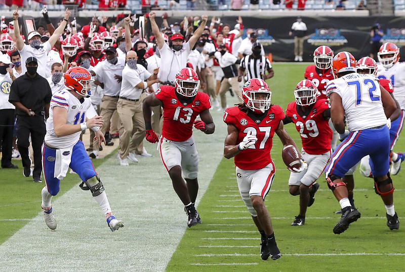 Georgia defensive back Eric Stokes (27) returns an interception for a touchdown during the second quarter of a NCAA college football, Saturday, Nov. 7, 2020, in Jacksonville, Fla. (Curtis Compton/Atlanta Journal-Constitution via AP)