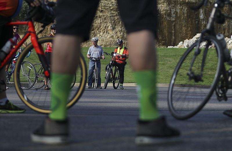 <p>Liv Paggiarino/News Tribune</p><p>Dirk Merrell and Shaun Zimmerman, background, listen to biking instructors giving an overview of the community bike ride before embarking on the 10-mile journey in July. The last community bike ride of the 2020 season is set for Saturday morning.</p>