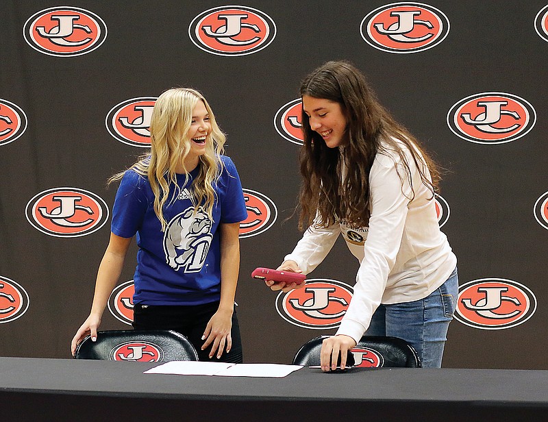 Jefferson City's Hannah Nilges and Sarah Linthacum laugh together after posing for photos to symbolize the signing of their letters of intent to play basketball at Drake and Missouri, respectively, on Wednesday afternoon at Fleming Fieldhouse.