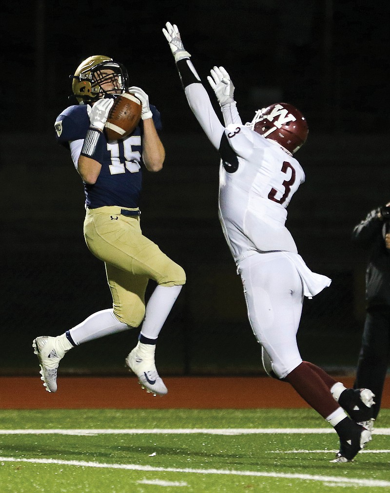 Helias receiver Cole Stumpe leaps into the air for a catch as Warrensburg defensive back Shelby Pittsenbarger defends during Friday night's Class 4 District 6 championship game at Ray Hentges Stadium.