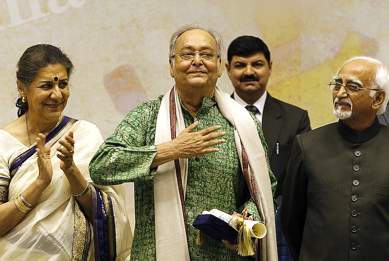 FILE- In this May 3, 2012 file photo, Bengali language film actor Soumitra Chatterjee, center, gestures after receiving the Dadasahab Phalke Award for the year 2011, as Indian Vice President Hamid Ansari, right, and Indian Minister for Information and Broadcasting Ambika Soni look on, during the 59th National Film Awards in New Delhi, India. Chatterjee, the legendary Indian actor with more than 200 movies to his name and famed for his work with Oscar-winning director Satyajit Ray, has died. He was 85. (AP Photo/ Manish Swarup, File)