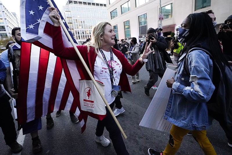A woman gestures as she argues with a counter-protester after supporters of President Donald Trump held marches Saturday, Nov. 14, 2020, in Washington. (AP Photo/Julio Cortez)