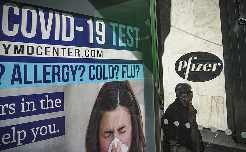 A bus stop ad for COVID-19 testing is shown outside Pfizer world headquarters in New York on Monday Nov. 9, 2020. Pfizer says an early peek at its vaccine data suggests the shots may be 90% effective at preventing COVID-19, but it doesn't mean a vaccine is imminent. (AP Photo/Bebeto Matthews)