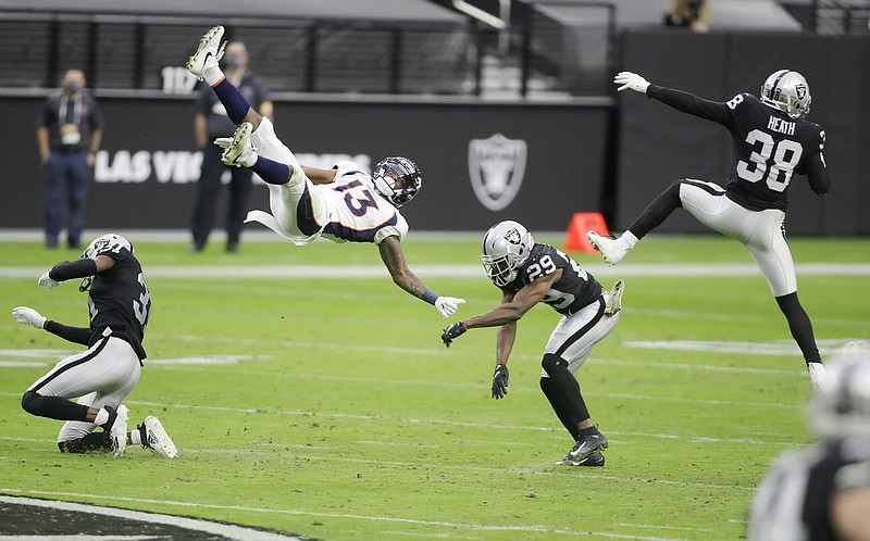 Raiders strong safety Jeff Heath (38) makes an interception on a pass intended for Broncos wide receiver K.J. Hamler who was covered by Raiders free safety Lamarcus Joyner (29) during the first half of Sunday's game in Las Vegas.