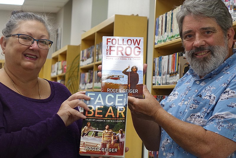 Roger Geiger, right, of Eagle Landing is giving copies of his two books, "Face The Bear" and "Follow the Frog," to Atlanta librarian Jackie Icenhower. 
