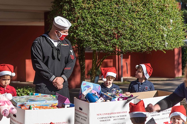 Hospital Corpsman 1st Class Gary Groves speaks with St. James Day School students while picking up a donation for Toys for Tots from the school on Monday. Across the elementary and middle school campuses, students donated more than 250 toys, with the kindergarten class contributing the highest number of toys.
