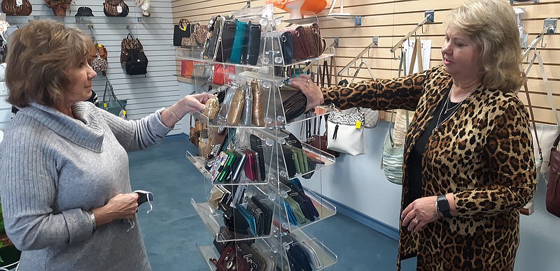Angela Harvey of Queen City, left, checks out the deals available at Handbag Bazaar with help from owner Barbara Dittrich. A longtime customer, Harvey remembers the shop from its original location at Town West Shopping Center next to Target.
