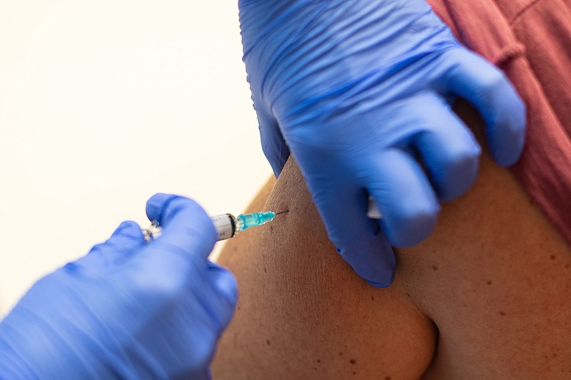 A health care worker administers a flu vaccine to a woman at a temporary vaccination centre during the second wave of Coronavirus (COVID-19) pandemic on October 16, 2020 in Barcelona, Spain. (David Ramos/Getty Images)