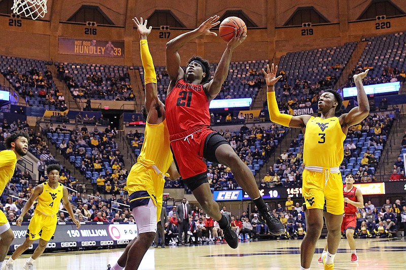 Austin Peay guard Terry Taylor (21) drives to the basket as West Virginia forward Derek Culver, behind, and West Virginia forward Gabe Osabuohien (3) defend during the first half of an NCAA college basketball game in Morgantown, W.Va., in this Thursday, Dec. 12, 2019, file photo. Taylor, the reigning Ohio Valley Conference player of the year, averaged 21.8 points and 11 rebounds last season and is the first player in school history to score at least 500 points in three consecutive seasons. (AP Photo/Kathleen Batten, File)