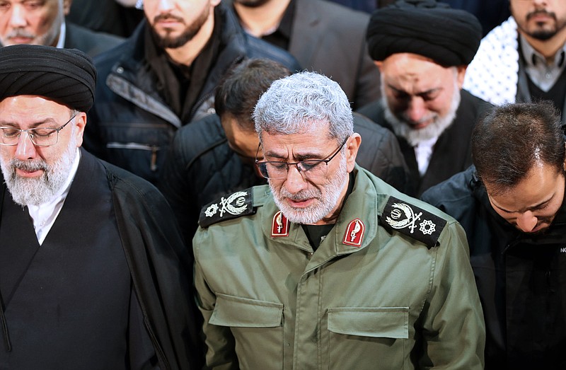 FILE - In this photo released by the official website of the Office of the Iranian Supreme Leader, Gen. Esmail Ghaani, newly appointed commander of Iran's Revolutionary Guards Quds Force, weeps while praying over the coffin of the force's previous head Gen. Qassem Soleimani at the Tehran University Campus in Tehran, Iran, Monday, Jan. 6, 2020.  On Friday, Nov. 20, two Iraqi officials say Iran has instructed allies in the Middle East to be on high alert and avoid provoking tensions with the U.S. that could give an outgoing Trump Administration cause to launch attacks in his final weeks in office.   (Office of the Iranian Supreme Leader via AP)
