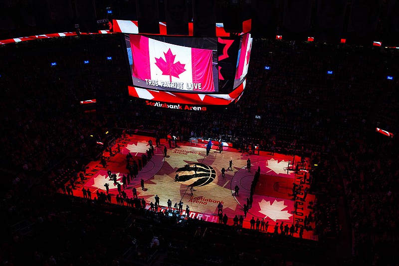 In this April 16, 2019, file photo, fans sing the Canadian national anthem before Game 2 of an NBA basketball first-round playoff series between the Orlando Magic and the Toronto Raptors in Toronto. The Canadian government has denied a request by the NBA and the Raptors to play in Toronto amid the pandemic. An official familiar with the federal government's decision told The Associated Press on Friday, Nov. 20, 2020, there is too much COVID-19 circulating in the United States to allow for cross-border travel that is not essential. (Nathan Denette/The Canadian Press via AP, File)