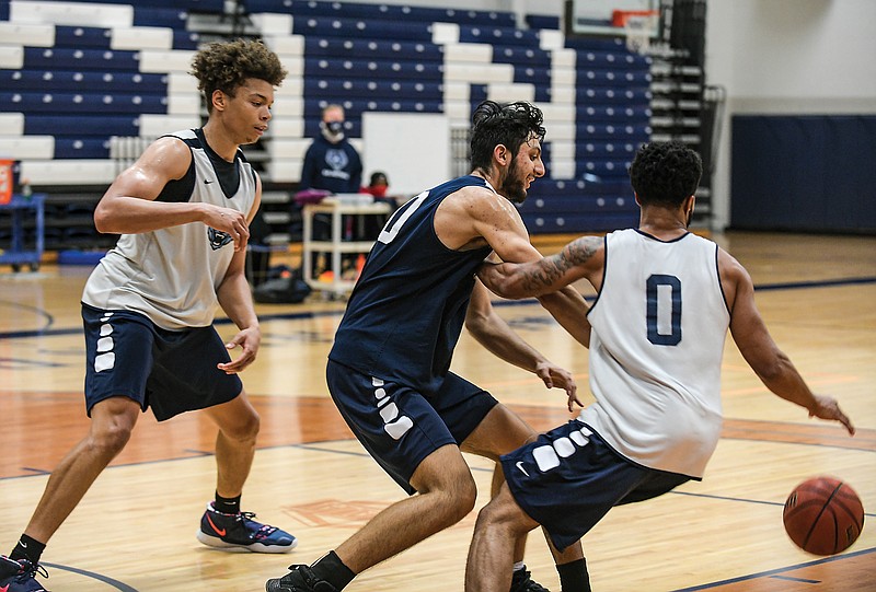 DaMani Jarrett (left) waits to assist teammate Cameron Potts (right) as fellow Lincoln Blue Tiger Arash Yaqubi (center) tries to steal the ball during a practice last month at Jason Gym.
