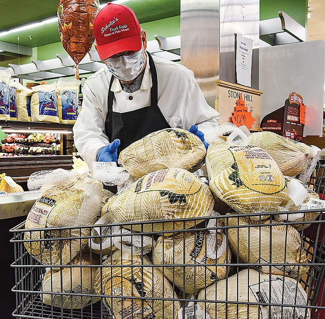John Jones, of the Schulte's Meat Department, brings a cart of turkeys to the cooler as it gets picked through. The store was busy late last week with shoppers stocking up for the upcoming Thanksgiving holiday.