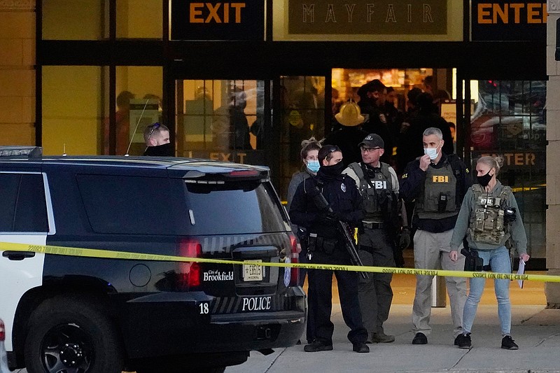 FBI officials and police stand outside the Mayfair Mall after a shooting, Friday, Nov. 20, 2020, in Wauwatosa, Wis. Multiple people were shot Friday afternoon at the mall. Wauwatosa Mayor Dennis McBride says in a statement that a suspect remains at large after the shooting at Mayfair Mall.  (AP Photo/Nam Y. Huh)