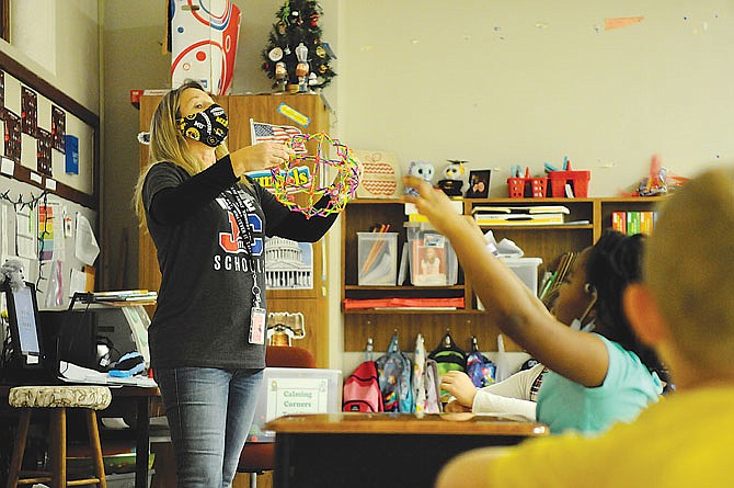 East Elementary School counselor Ruthie Eichholz teaches second-grade students calming strategies Friday. Using an expanding ball, Eichholz demonstrates how to calm down with a breathing technique. She introduced students to items inside a "calm-down tool box" for the classroom's calming corner, a place where students can go to cool down when they feel upset. The kit includes items such as noise-canceling headphones, stress balls and water lava bubbles.