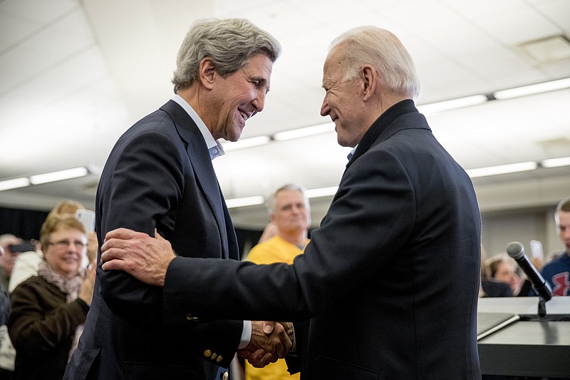 FILE - In this Feb. 1, 2020, file photo Democratic presidential candidate former Vice President Joe Biden smiles as former Secretary of State John Kerry, left, takes the podium to speak at a campaign stop at the South Slope Community Center in North Liberty, Iowa. (AP Photo/Andrew Harnik, File)