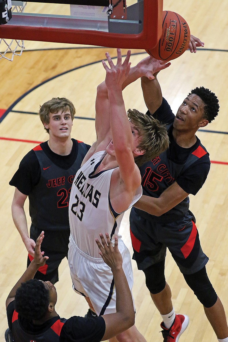 Jefferson City's Sterling DeSha slaps the ball out of hands of Helias' Colby LeCuru during a game last season at Fleming Fieldhouse.