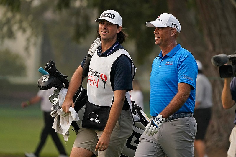 Stewart Cink, right, walks with his caddie and son, Reagan Cink, down the 18th fairway of the Silverado Resort North Course during the final round of the Safeway Open PGA golf tournament in Napa, Calif., in this Sunday, Sept. 13, 2020, file photo. Cink revealed Wednesday, Nov. 18, he and his wife had the coronavirus in March and didn't realize it until antibody tests were positive in June. (AP Photo/Eric Risberg, File)