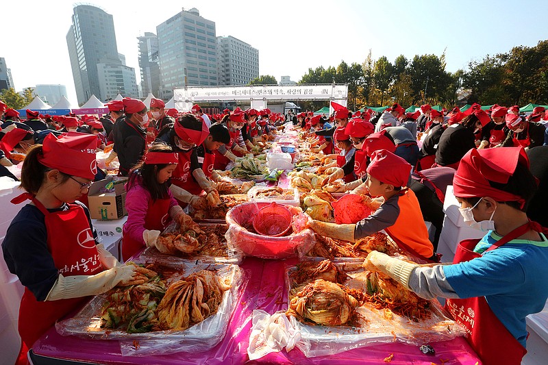 Participants make kimchi, a staple Korean side dish made of fermented vegetables, for a Guinness World Record for the largest number of people making kimchi at one place during the Seoul Kimchi Festival at Seoul Plaza in Seoul, Sunday, Nov. 4, 2018. More than 3,000 people made kimchi to donate to needy neighbors in preparation for the winter season. (AP Photo/Ahn Young-joon)