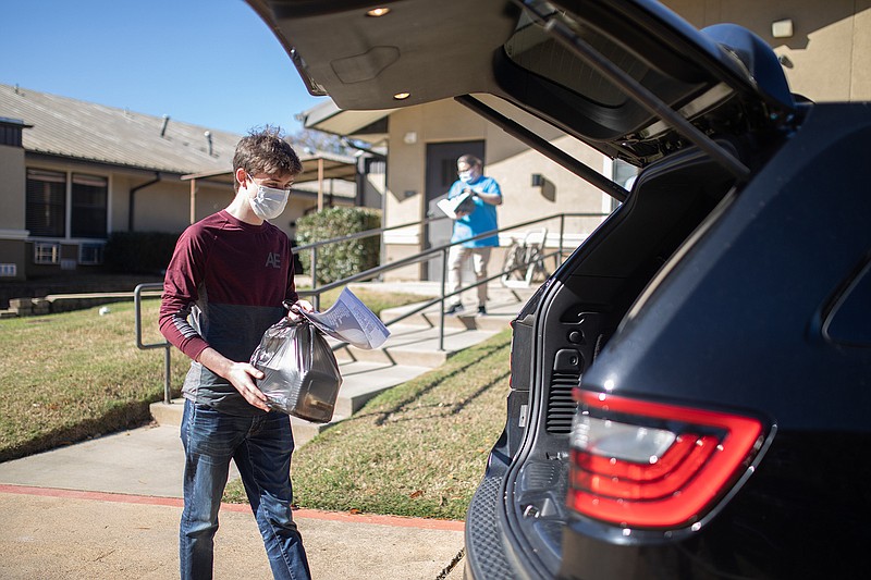  Clayton Jones packs a car with Thanksgiving plates Wednesday at Retreat at Kenwood. The staff delivered the meals to seniors in the Texarkana area.