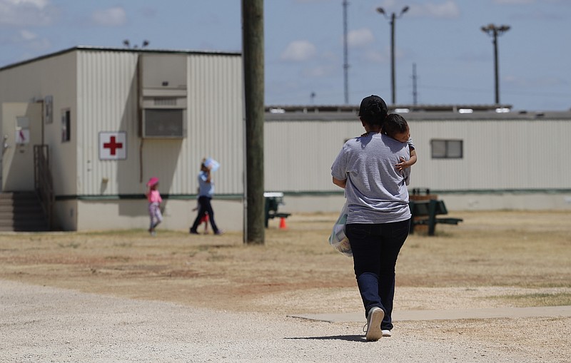 FILE - In this Aug. 23, 2019 file photo, immigrants seeking asylum walk at the ICE South Texas Family Residential Center, in Dilley, Texas. Late Wednesday, Nov. 25, 2020, the U.S. government appealed a judge's order barring the expulsions of immigrant children who crossed the border alone, a policy enacted during the coronavirus pandemic to deny the children asylum protections. (AP Photo/Eric Gay, File)