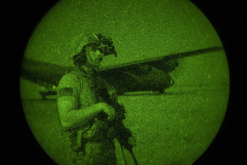 U.S. Army Spc. Dominic Deitrick, assigned to the 1-186th Infantry Battalion, Task Force Guardian, Combined Joint Task Force - Horn of Africa, seen through a night-vision device, provides security for a 75th Expeditionary Airlift Squadron (EAS) C-130J Super Hercules during unloading and loading operations Friday, June 12, 2020 at an unidentified location in Somalia. No country has been involved in Somalia's future as much as the United States but now the Trump administration is thinking of withdrawing the several hundred U.S. military troops from the nation at what some experts call the worst possible time. (Tech. Sgt. Christopher Ruano/Combined Joint Task Force - Horn of Africa via AP)