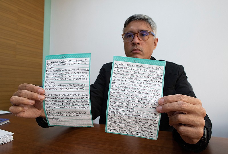 Jesus Loreto, an attorney representing Tomeu Vadell, one of six U.S. oil executives jailed for three years in Venezuela, shows a letter written by Vadell, in Caracas, Venezuela, Wednesday, Nov. 25, 2020. In the letter provided exclusively to The Associated Press on Tuesday, Nov. 24, 2020, Vadell pleads for freedom, reflects on his past and shares the pain he feels over being separated from his wife, three adult children and a newborn grandson he's never held. (AP Photo/Ariana Cubillos)
