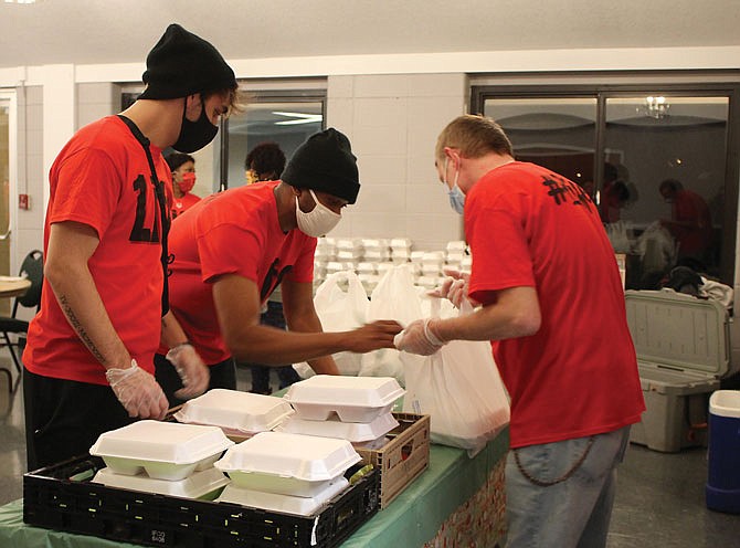 Red-shirted OneLife volunteers scurried around the John C. Harris Community Center all evening, preparing, serving and delivering free Thanksgiving dinners.