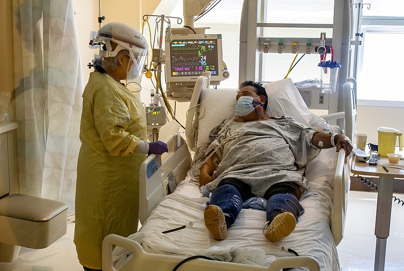 In this image from July, ICU nurse Lynda Tegan checks on COVID-19 patient Jose Mariscal, 66, who has been in the ICU for four days at Arrowhead Regional Medical Cente in Colton, California. This ICU has only 2 more beds available for Covid patients, but has the capacity to expand to more beds if needed.(Gina Ferazzi / Los Angeles Times/TNS)