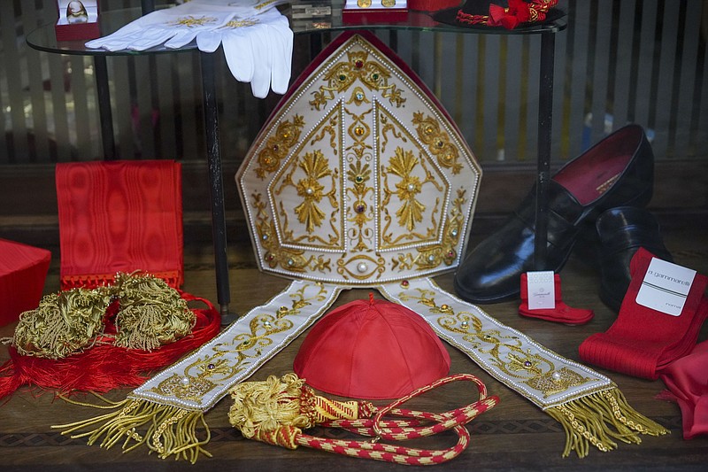 Cardinal clothing accessories are seen on display in the window of the Gammarelli clerical clothing shop, in Rome, Thursday, Nov. 26, 2020. The consistory to elevate new cardinals scheduled for Saturday, Nov. 28, in the time of coronavirus is like nothing the Holy See has ever seen. A handful of soon-to-be cardinals are in protective coronavirus quarantine, including African-American, Cardinal-designate Wilton Gregory, archbishop of Washington who explained that a U.S.-based ecclesiastical tailor took his measurements while he was still in Washington and sent them to Gammarelli, which then made them to order and sent them to Santa Marta hotel where he is undergoing the quarantine. (AP Photo/Andrew Medichini)