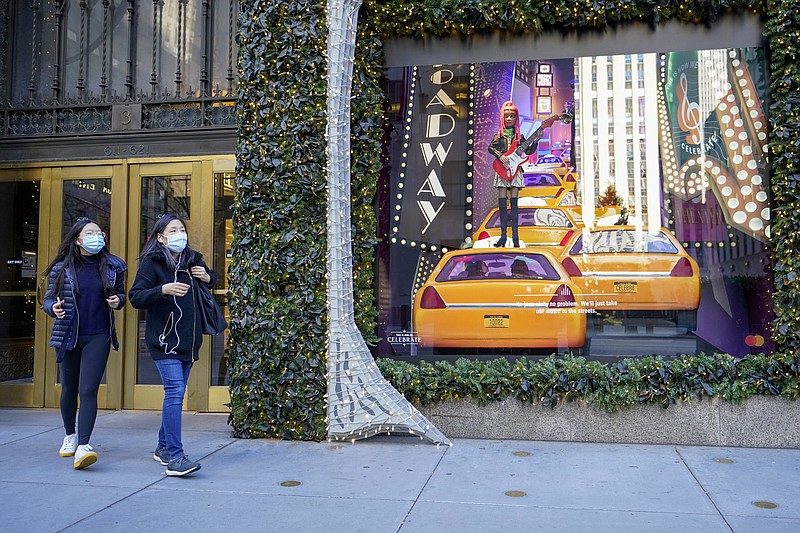 Black Friday shoppers wear face masks as the leave Saks Fifth Avenue flagships store empty handed, Friday, Nov. 27, 2020, in New York. (AP Photo/Mary Altaffer)