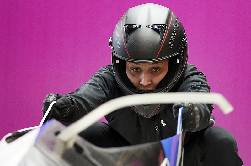 In this Feb. 16, 2014, file photo, breakman Lolo Jones, of the United States, prepares for a training session with her teammate Jazmine Fenlator for the women's bobsleigh at the 2014 Winter Olympics, in Krasnaya Polyana, Russia.