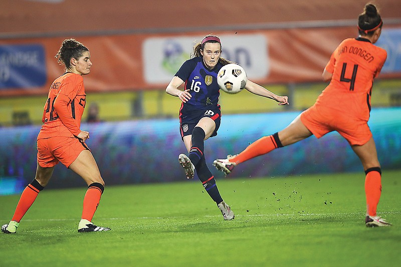 Rose Lavelle (center) of the United States scores her team's first goal, taking a shot between the Netherlands' Merel van Dongen (right) and Dominique Janssen (left) during Friday's international friendly match at Rat Verlegh Stadium in Breda, Netherlands.