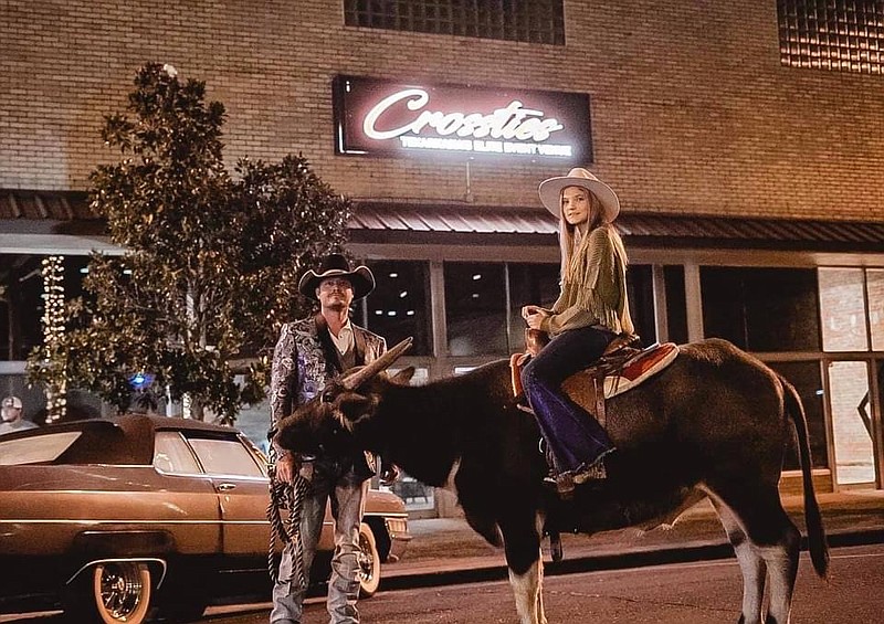 Joe and Joy Gay hang out with Wilson the water buffalo in front of Crossties in downtown Texarkana. (Photo courtesy of Brian Jones)
