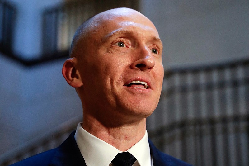 In this Nov. 2, 2017, photo, Carter Page, a foreign policy adviser to Donald Trump's 2016 presidential campaign, speaks with reporters following a day of questions from the House Intelligence Committee, on Capitol Hill in Washington.  Page, who was the target of a secret surveillance warrant during the FBI's Russia investigation says in a federal lawsuit filed Friday, Nov. 27, 2020,  that he was the victim of "unlawful spying." The suit from Carter Page alleges a series of omissions and errors made by FBI and Justice Department officials in applications they submitted to the Foreign Intelligence Surveillance Court to eavesdrop on Page on suspicion that he was an agent of Russia.(AP Photo/J. Scott Applewhite)