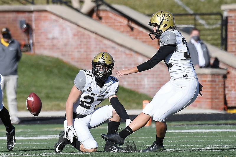 Vanderbilt's Sarah Fuller (right) kicks off as Ryan McCord holds to start the second half of Saturday's game against Missouri at Faurot Field in Columbia. With the kick, Fuller became the first female to play in a Southeastern Conference football game.