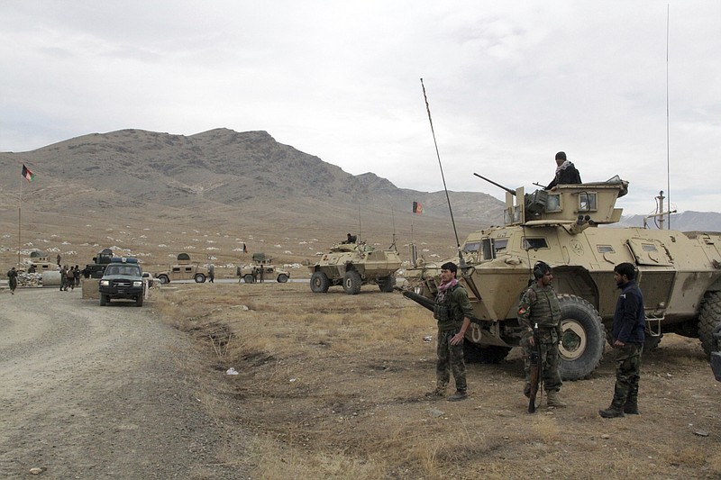 Afghan national army soldiers arrive at the site of a suicide bombing in Ghazni province west of Kabul, Afghanistan, Sunday, Nov. 29, 2020. Over 30 people were killed on Sunday in two separate suicide bombings in Afghanistan that targeted a military base and a provincial chief, officials said. (AP Photo/Rahmatullah Nikzad)